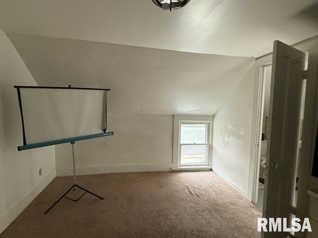 bonus room with lofted ceiling and carpet flooring