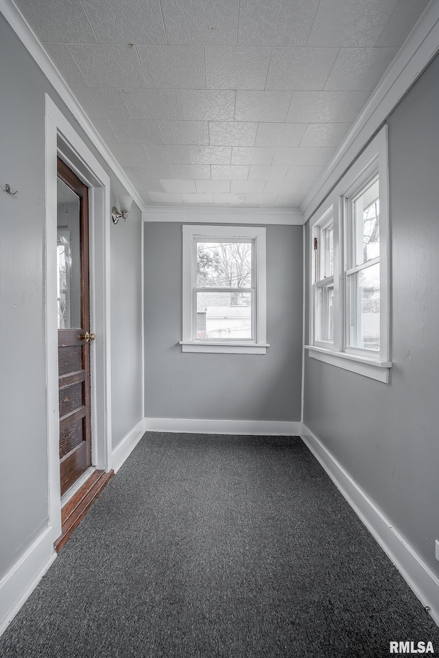 carpeted empty room featuring crown molding