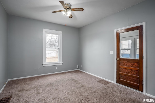 carpeted spare room featuring ceiling fan