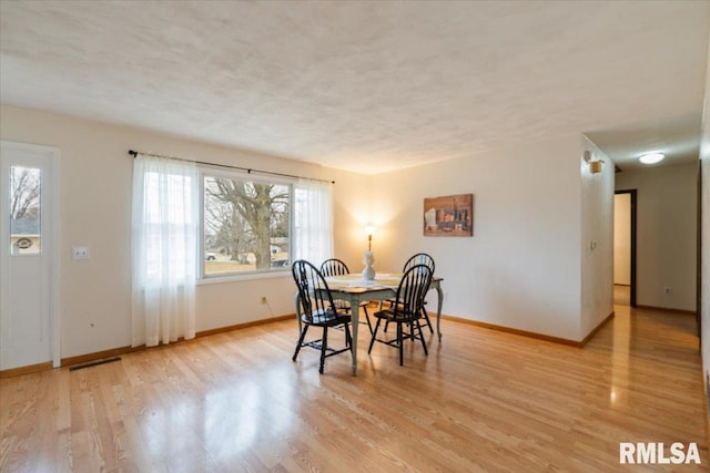 dining area featuring light hardwood / wood-style floors and a textured ceiling