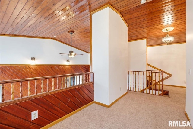 hallway featuring carpet floors, wood ceiling, vaulted ceiling, and wood walls