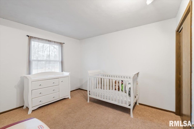 carpeted bedroom featuring a nursery area