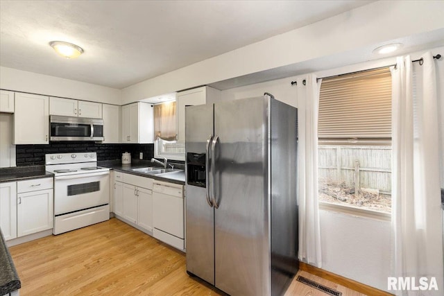 kitchen with stainless steel appliances, sink, and white cabinets