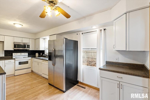 kitchen featuring stainless steel appliances, sink, and white cabinets