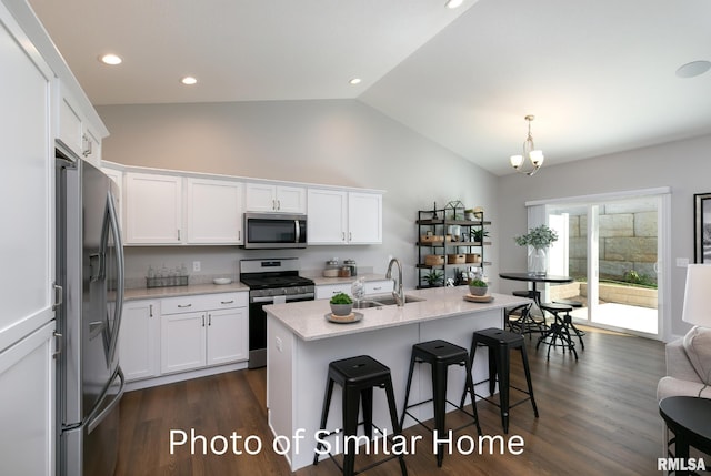 kitchen featuring decorative light fixtures, sink, stainless steel appliances, and white cabinets