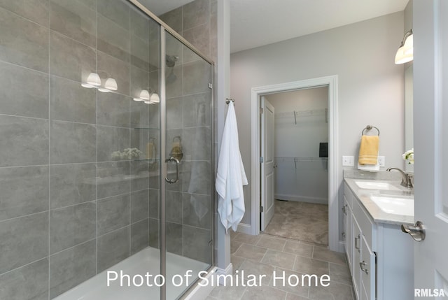 LOT38 Frank Ct, Le Claire, IA 52753 - bathroom featuring double vanity, a sink, a walk in closet, and a stall shower