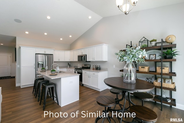 kitchen with white cabinetry, appliances with stainless steel finishes, dark wood-type flooring, and a kitchen island with sink