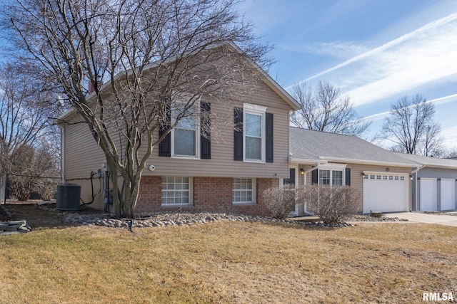 split level home with a garage, central AC unit, and a front lawn