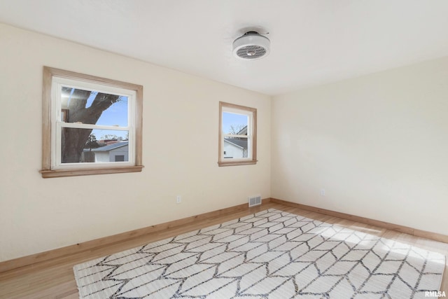 unfurnished room with hardwood / wood-style flooring and a healthy amount of sunlight