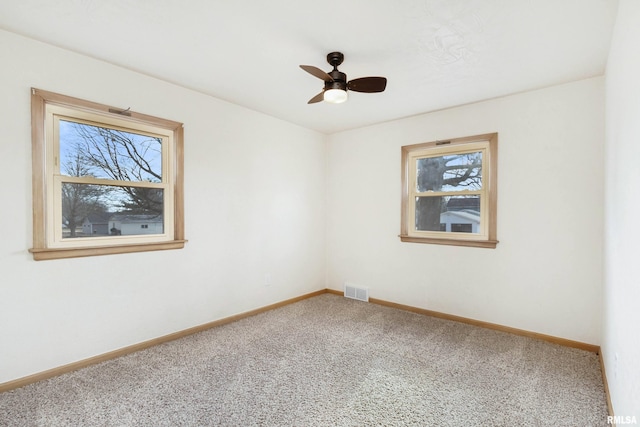 carpeted spare room featuring ceiling fan