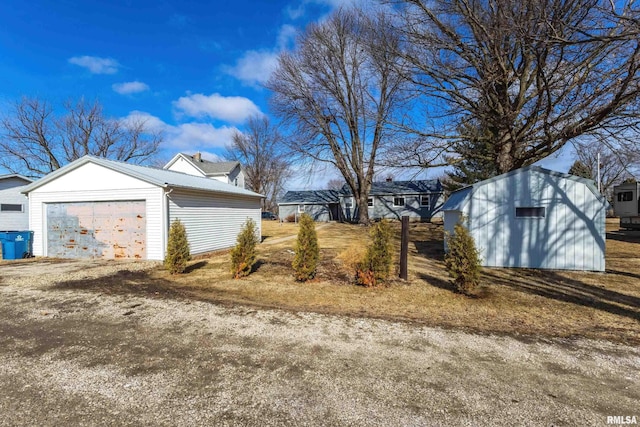 view of property exterior featuring a garage and an outbuilding