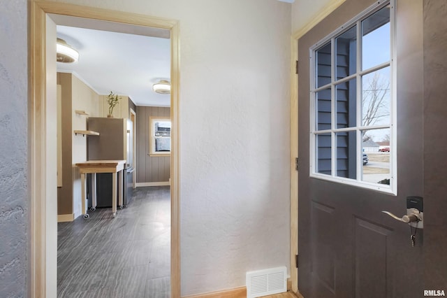 doorway to outside featuring crown molding and hardwood / wood-style floors