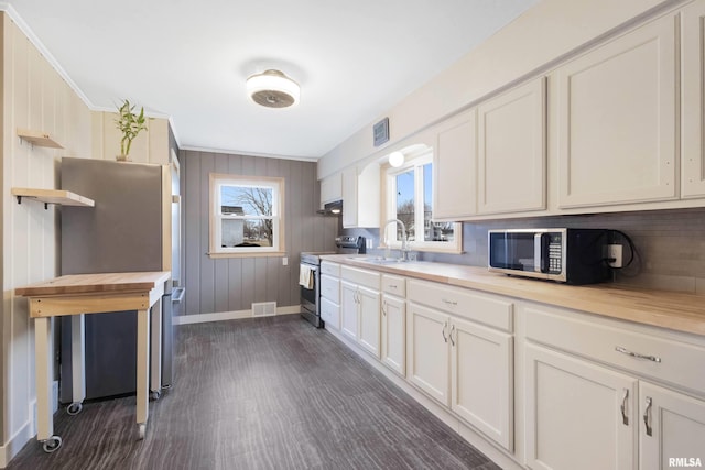 kitchen with appliances with stainless steel finishes, dark hardwood / wood-style floors, sink, and white cabinets