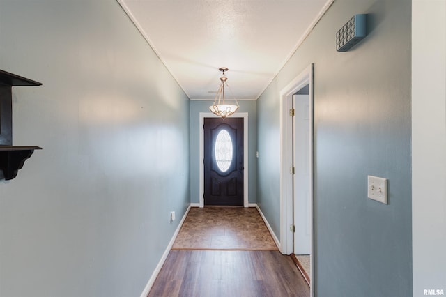 doorway to outside with crown molding and wood-type flooring