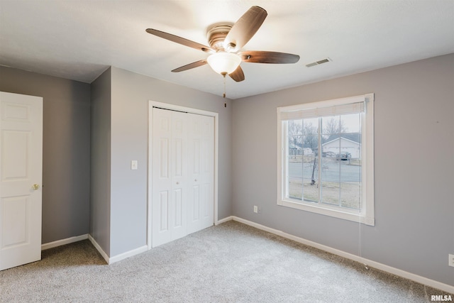 unfurnished bedroom with ceiling fan, carpet floors, and a closet