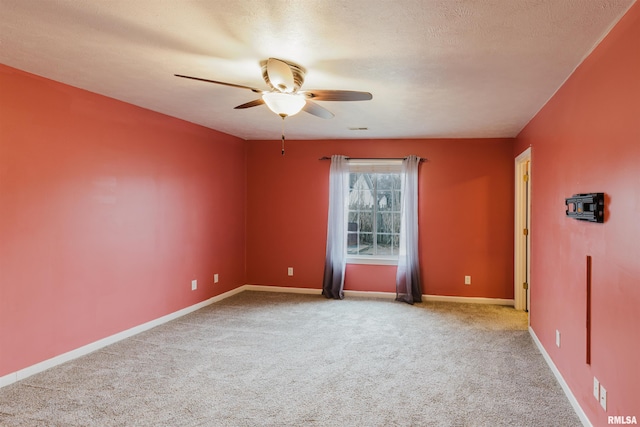 empty room with a textured ceiling, light colored carpet, and ceiling fan