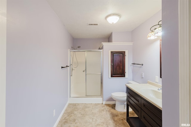 bathroom with tile patterned flooring, vanity, toilet, and walk in shower