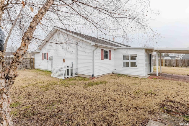 back of property with central AC and a lawn