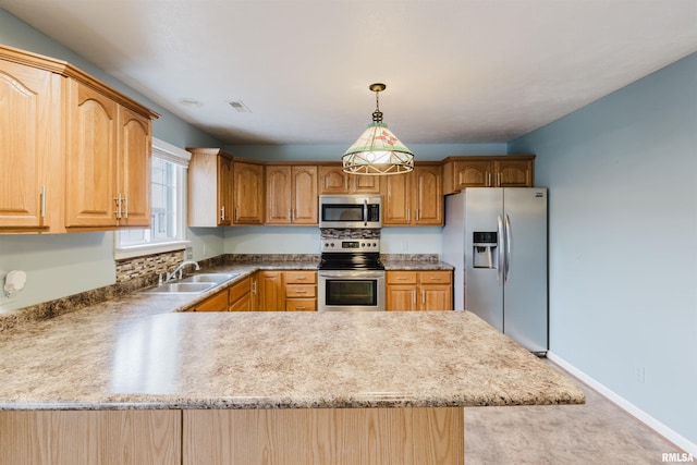 kitchen with pendant lighting, sink, stainless steel appliances, and kitchen peninsula