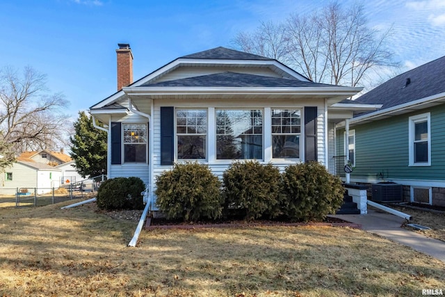 view of front of home with central AC and a front yard