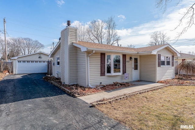 single story home featuring an outbuilding and a garage