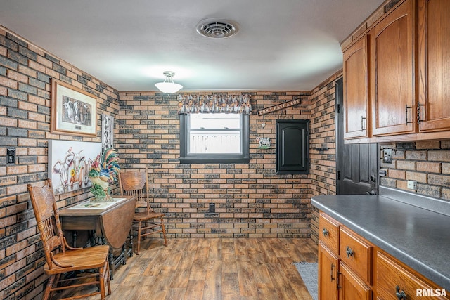 kitchen with brick wall and dark hardwood / wood-style floors