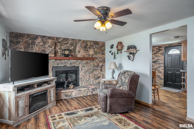 living room featuring a fireplace, dark wood-type flooring, and ceiling fan