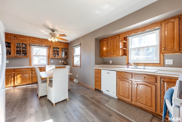 kitchen with sink, wood-type flooring, a textured ceiling, dishwasher, and stove