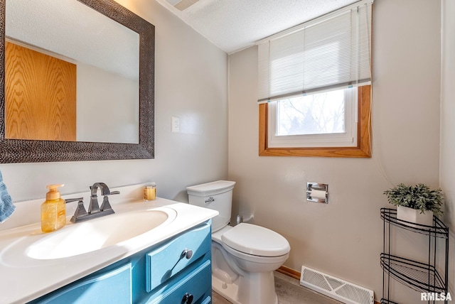 bathroom featuring vanity, a textured ceiling, and toilet