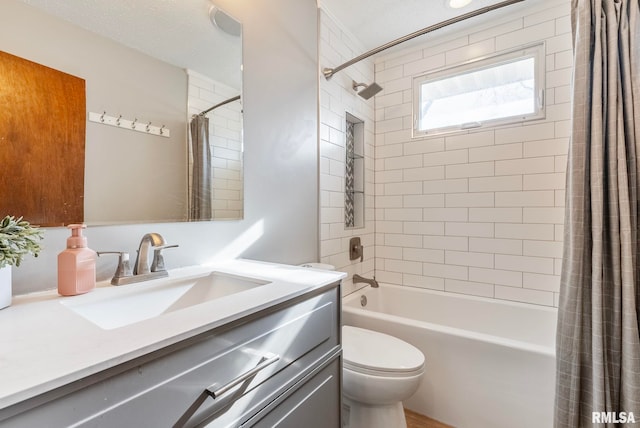 full bathroom featuring vanity, shower / tub combo with curtain, a textured ceiling, and toilet