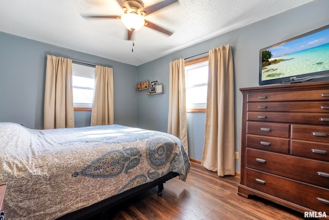 bedroom with dark hardwood / wood-style flooring, multiple windows, and ceiling fan