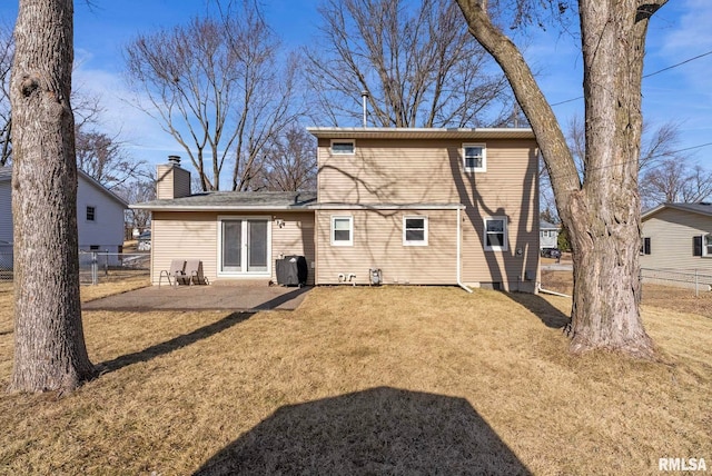 back of property with a yard and a patio area