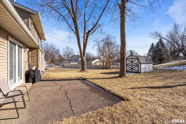 view of yard featuring a storage shed and a patio