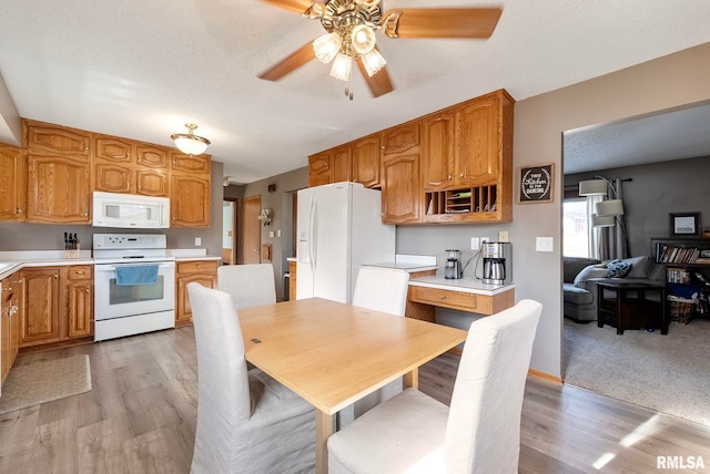 kitchen with ceiling fan, light wood-type flooring, a textured ceiling, and white appliances