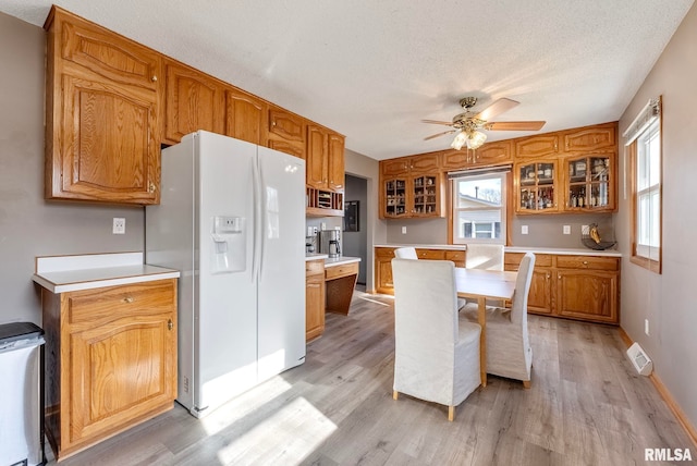 kitchen featuring ceiling fan, light wood-type flooring, a textured ceiling, and white fridge with ice dispenser