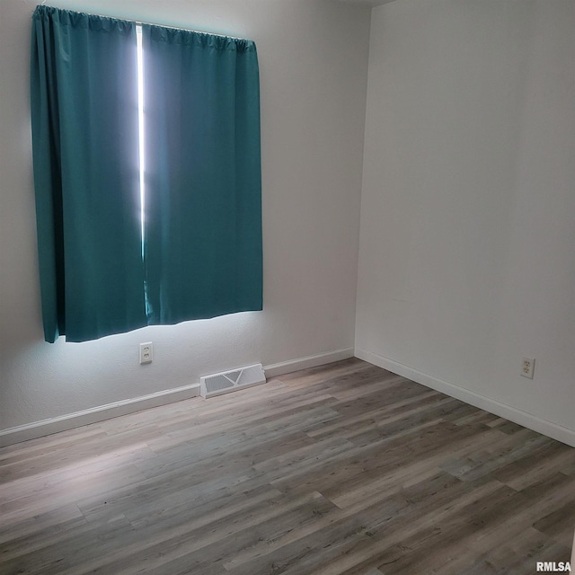 unfurnished room with wood-type flooring