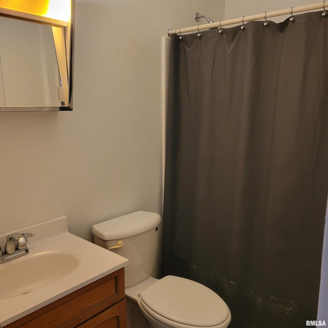 bathroom featuring walk in shower, vanity, and toilet