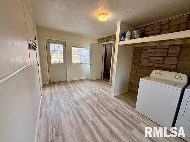 washroom featuring a textured ceiling, independent washer and dryer, and light hardwood / wood-style flooring