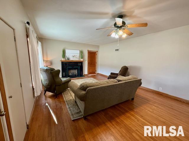 living room with wood-type flooring and ceiling fan