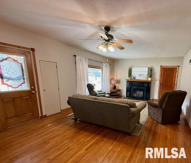 living room featuring hardwood / wood-style floors and ceiling fan