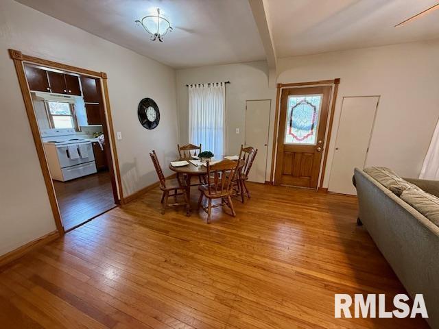 dining room with light hardwood / wood-style flooring and beamed ceiling