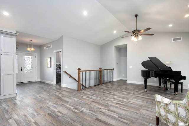 interior space with lofted ceiling, washer / clothes dryer, light hardwood / wood-style floors, and ceiling fan