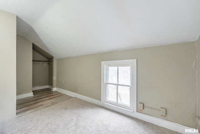 unfurnished bedroom with vaulted ceiling, carpet, and a closet