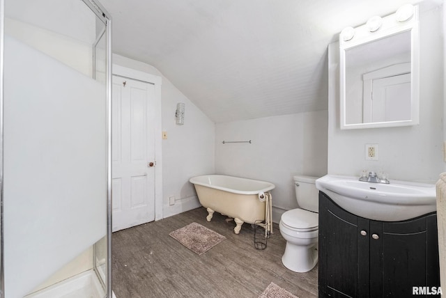 bathroom featuring lofted ceiling, hardwood / wood-style floors, vanity, a tub to relax in, and toilet