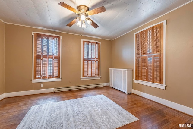 empty room featuring hardwood / wood-style flooring, ornamental molding, ceiling fan, and baseboard heating