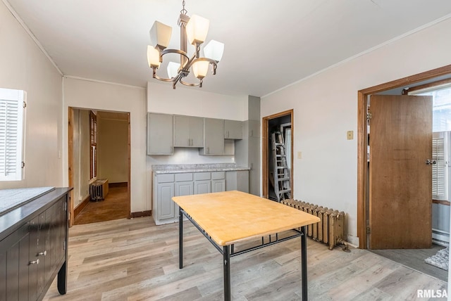 dining area featuring ornamental molding, radiator, and light hardwood / wood-style flooring