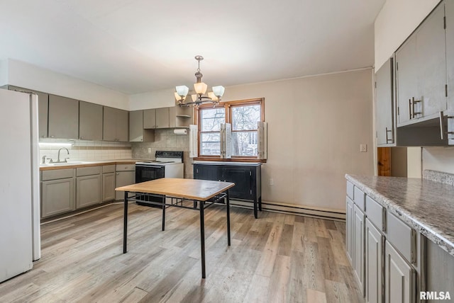 kitchen with sink, tasteful backsplash, an inviting chandelier, white appliances, and light hardwood / wood-style floors