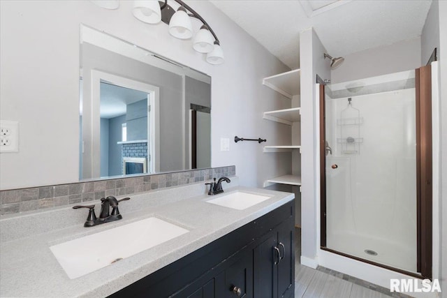 bathroom featuring a shower with door, vanity, and backsplash