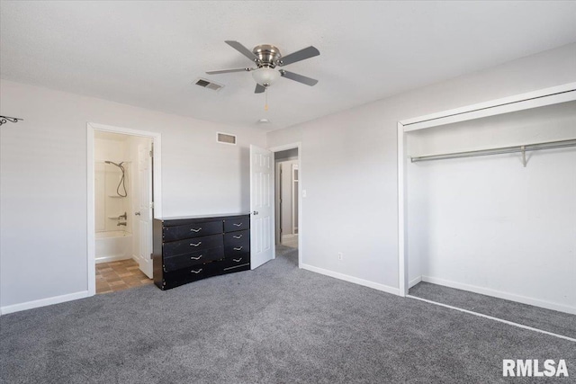 unfurnished bedroom featuring ensuite bathroom, a closet, ceiling fan, and dark colored carpet