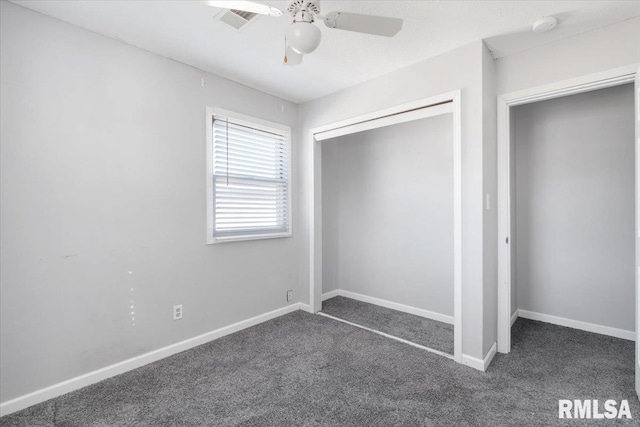 unfurnished bedroom with ceiling fan, dark carpet, and a closet